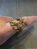 Ring on hand showing front feather motif