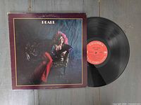 Front cover of Janis Joplin Pearl album beside vinyl record