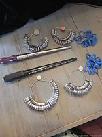 All ring sizing tools laid out: four metal gauge sets, two mandrels, several groups of blue plastic gauges