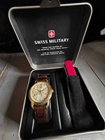 Set inside Swiss Military tin showing watch and knife