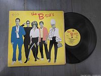 Front sleeve with record partially exposed showing yellow center label