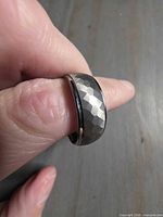 Faceted tungsten ring on finger showing exterior texture