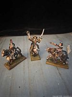 Front view of three painted metal cavalry miniatures on bases