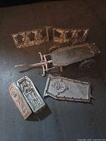All six pewter Black Coach parts laid out: chassis, side panels, coffin pieces, roof panel