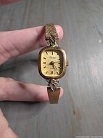 Front view showing dial marked Rochelle, gold-tone case, leaf and rhinestone accents