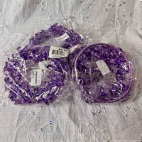 Four sealed purple acrylic bead rings grouped together