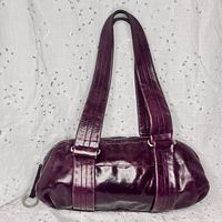 Front view of deep purple leather shoulder bag showing straps and sheen