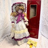 Full doll on stand with original box and certificate