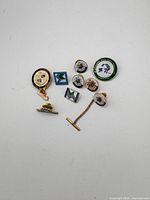 Front view of all 12 pins showing designs and colours