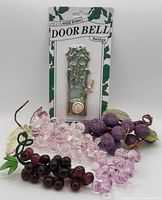Entire lot showing brass doorbell button package and four grape clusters of various materials