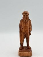 Front view of carved wooden bearded man figure on base
