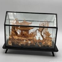 Full front view of cork diorama inside glass case on black base