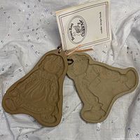 Front view of both stoneware cookie presses with booklet visible