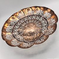 Top view of pierced silver-plated dish showing scalloped rim and openwork pattern