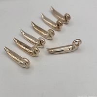 Seven silver-plated swan utensil rests angled in rows