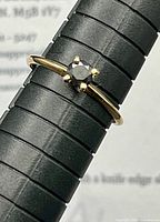 Ring on mandrel showing black diamond and prong setting