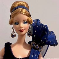 Close-up of doll’s face, earrings and headband