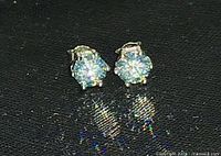 Front view of both blue moissanite stud earrings in 925 settings