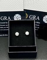 Earrings in display box with GRA certificates visible