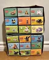 Front view of 18 boxed HSANHE micro-brick sets stacked in two cardboard trays