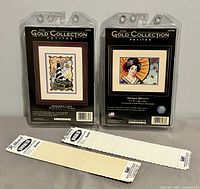 Both sealed Dimensions kits and two Aida cloth pieces