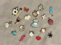 All 18 metal and enamel charms laid out