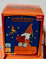 Front of sealed orange LiNooS Snoopy Halloween blind box showing product name and age rating