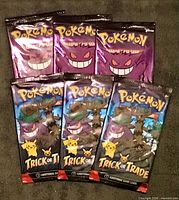 Front view showing six sealed booster packs (three purple Gengar art, three blue Pikachu art)