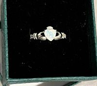 Ring in presentation box showing opal and Claddagh design