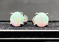 front view of both opal stud earrings in settings