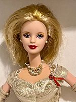Close-up of Barbie doll head and torso showing hairstyle, dress, necklace, red ribbon detail