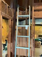 Full view of aluminum extension ladder leaning against framing