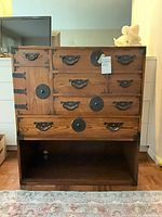 Front view of Baker dresser with multiple drawers, iron pulls and open cubby