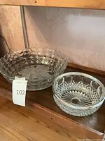 Both glass bowls side by side on shelf showing patterns and condition