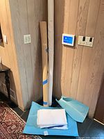 Tall white cotton fabric bolt, tan cotton roll, folded white linens at base