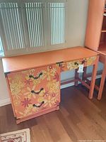 Front view of painted Drexel writing desk showing floral cabinet and overall design