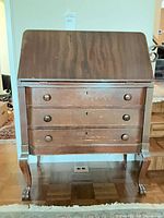 Full front view showing drop-front panel, three drawers and cabriole legs