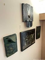 Four wall art pieces mounted on wall showing relative sizes and textures