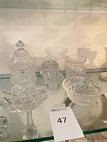 Group shot of five small crystal pieces on glass shelf