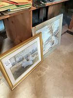 Both framed prints leaning against wall