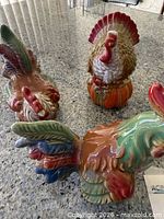 Three of the four ceramic turkeys frontal and side view