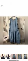 Front view of sleeveless denim dress hanging on hanger