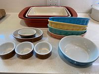 All ceramic bakeware pieces grouped on countertop showing colors, shapes and sizes