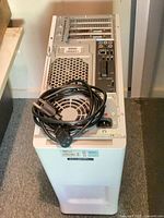 Rear view of Dell tower desktop PC with AC power cord placed on top