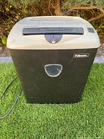 Front view of Fellowes paper shredder showing bin, brand logo, top controls, attached power cord