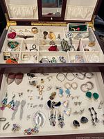 Open jewelry box showing full contents in compartments and tray
