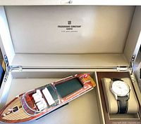 Open presentation box showing watch and wooden boat
