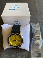 Watch on pillow with original box and spare bracelet in packaging