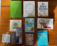 Overview of all miniature books, journals, card deck and bookmark packages laid out on wooden surface