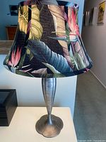 Full view of lamp with shade showing pewter base and tropical print fabric shade
